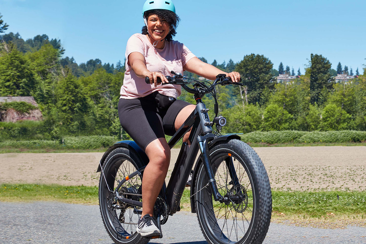 Woman in a helmet smiling and riding a RadRover 6 Plus High-step electric fat tire bike